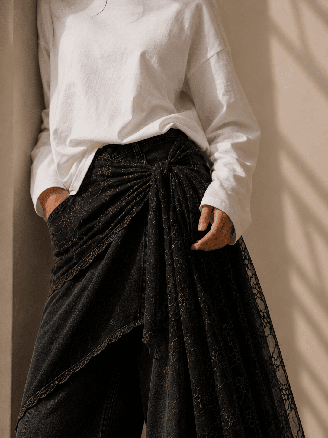 Détail d'un pantalon ample et de son drapé en dentelle