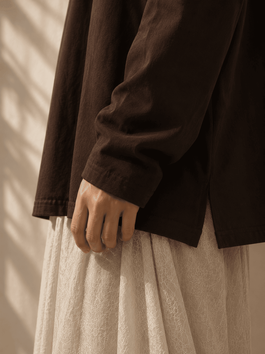Détail d'une chemise marron et de son poignet structuré